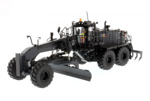 Niveleuse noire CATERPILLAR 18M3 avec conducteur en boite métal