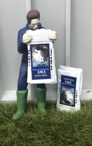 Fermier vidant un sac de nourriture pour moutons